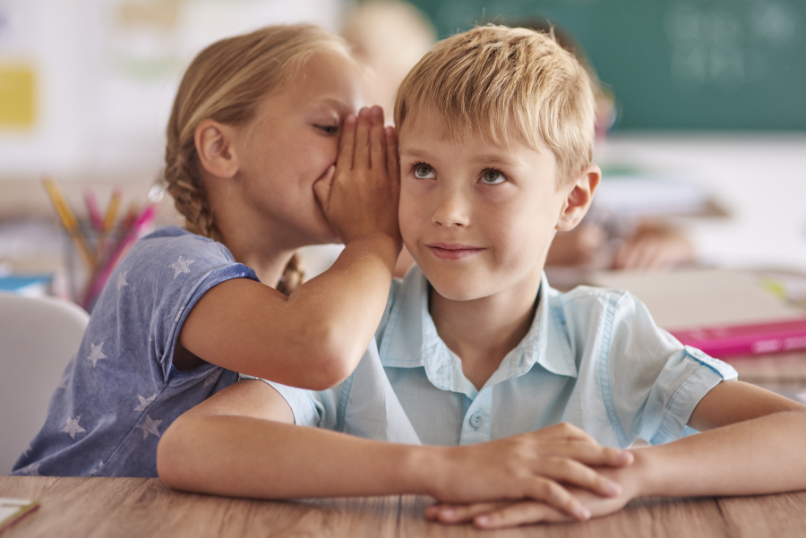 boy-girl-whispering-classroom